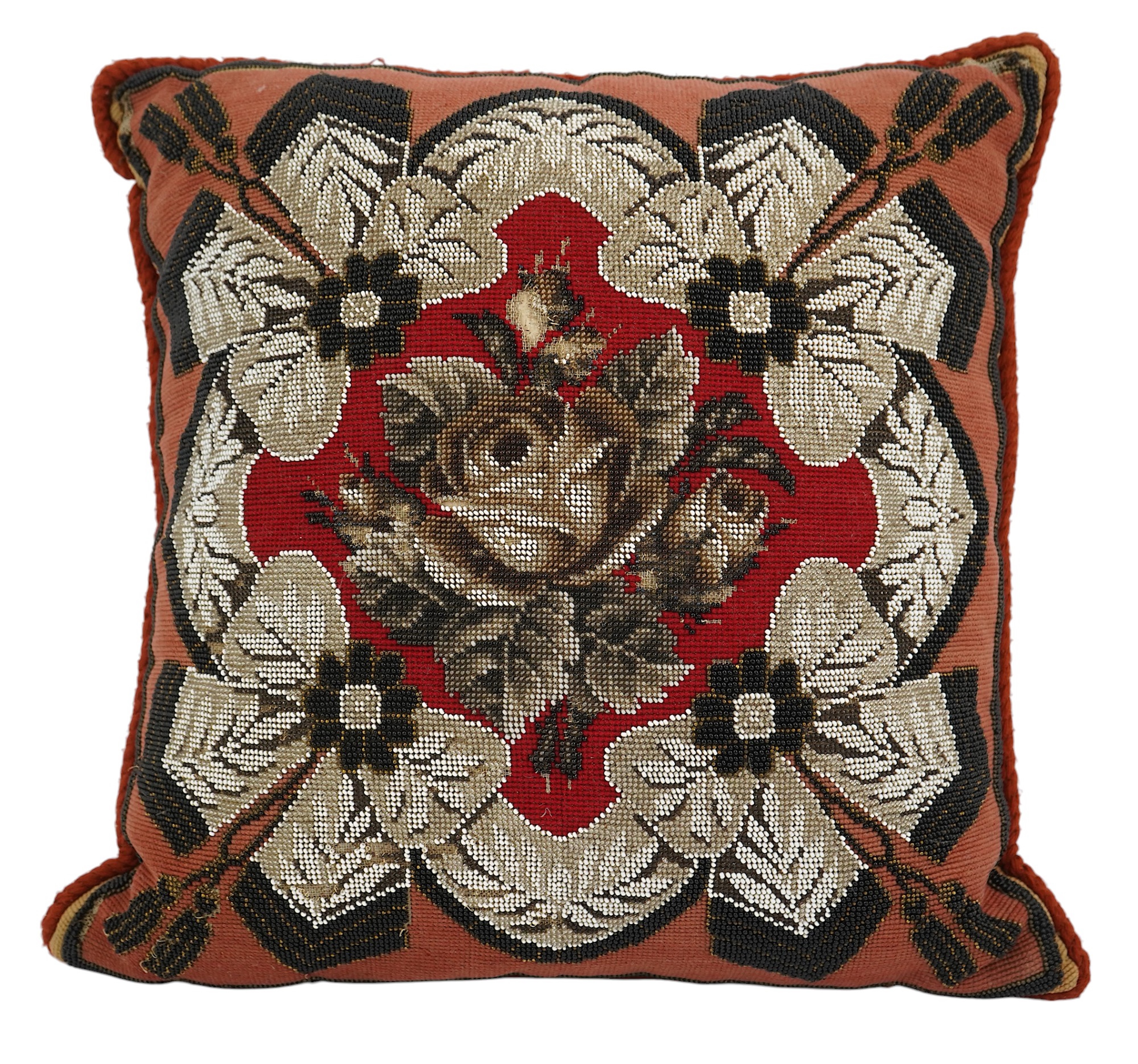 A 19th century Berlin bead worked cushion, the beadwork embroidered as a central rose, surrounded by an ornate tasseled swag, on a red wool worked background, 43cm x 45cm. Condition - some beadwork missing due to age and